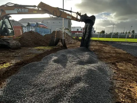 Stone tipped from the digger's bucket onto the subsoil