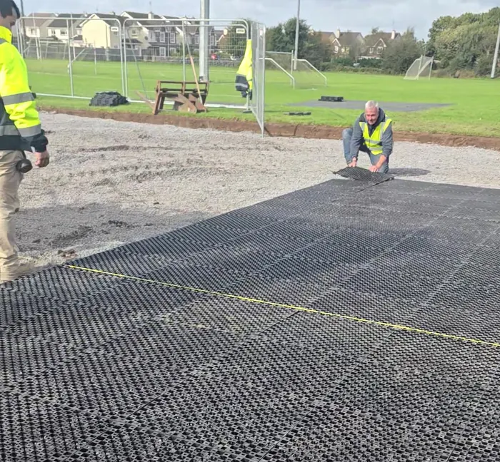 Our crew laying the drainage grid on the stone bed at Lakeview, Claregalway, with the GAA goals behind