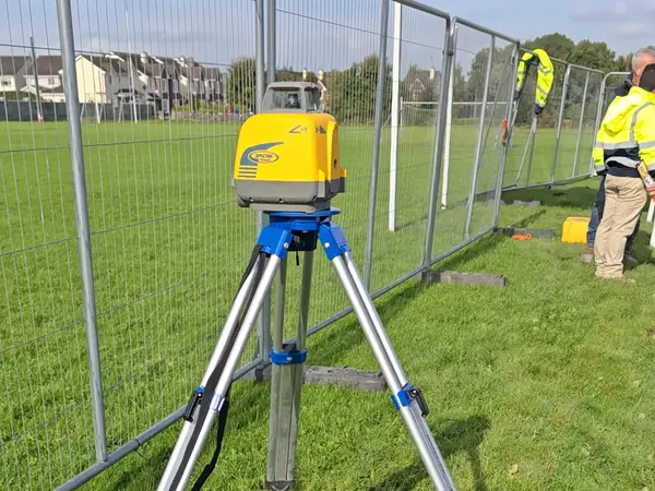 Our crew measuring the pitch at Lakeview with a laser level on its tripod and a levelling staff